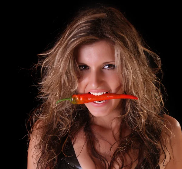 Krásná žena s červenou paprikou na černém pozadí — Stock fotografie