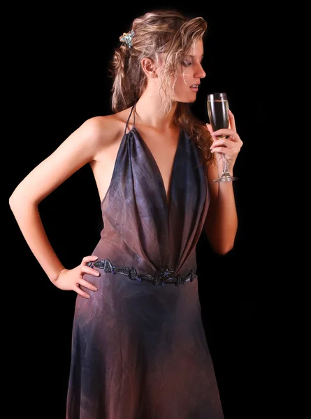 Mooie vrouw met een glas champagne op zwarte achtergrond — Stockfoto