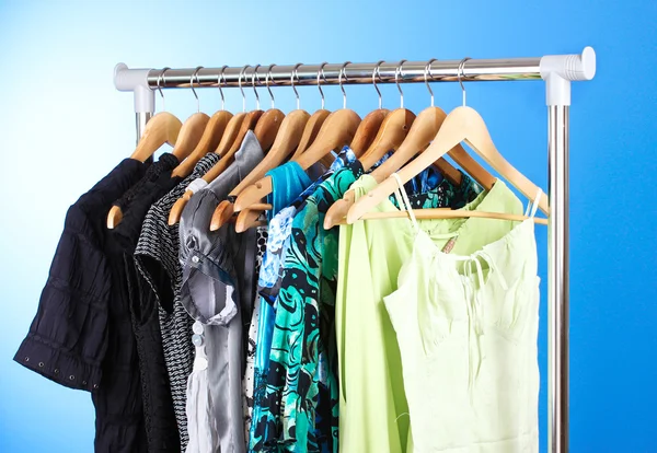 Different clothes on wooden hangers — Stock Photo, Image