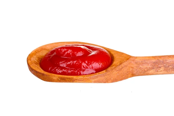 Ketchup saboroso em colher de madeira isolada em branco — Fotografia de Stock