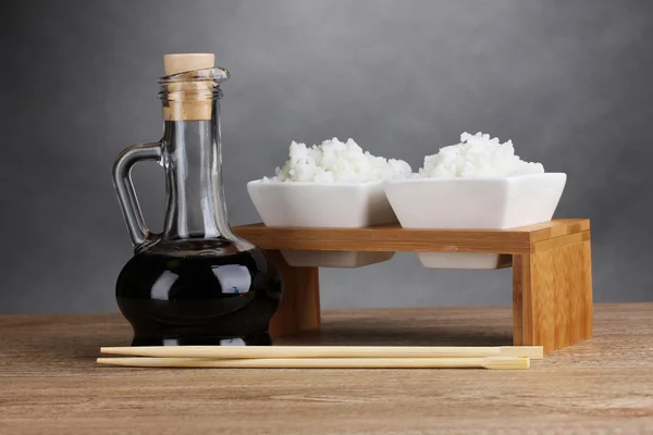 Bowls of cooked rice and soy sauce in jar — Stock Photo, Image