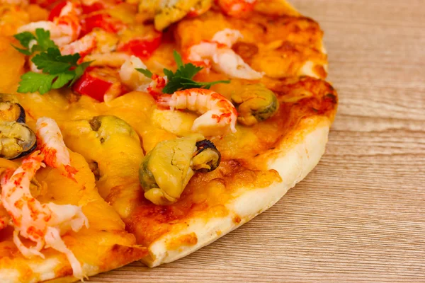 Délicieuse pizza aux fruits de mer sur table en bois — Photo