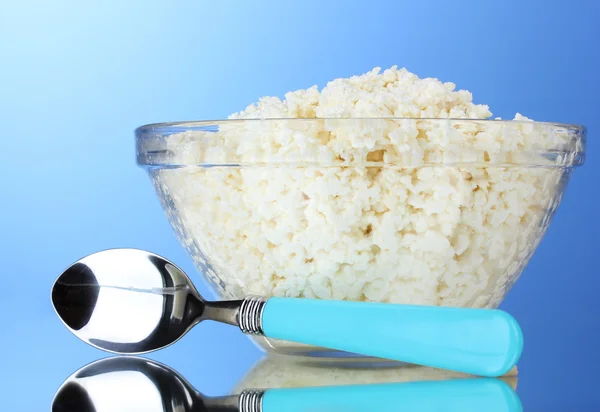 Tasty cottage cheese in bowl and spoon — Stock Photo, Image