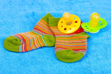 Bright baby socks and baby soothers clipart