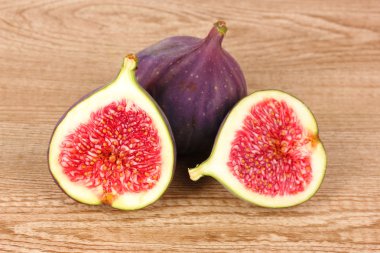 Ripe figs on wooden background clipart