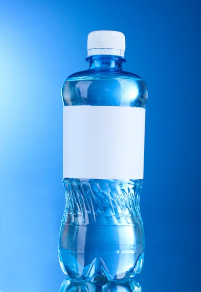 Jednu plastovou láhev vody na modrém pozadí — Stock fotografie