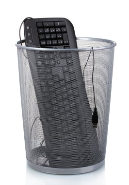 Old PC keyboard and mouse in metal trash bin isolated on white clipart