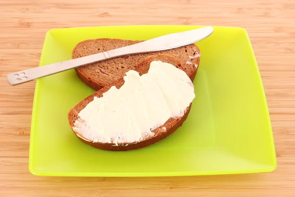 Nóż i chleb z masłem na talerzu — Zdjęcie stockowe