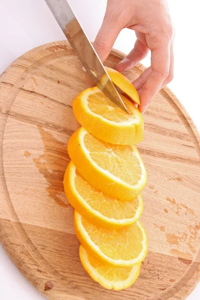Manos cortando naranjas sobre la mesa — Foto de Stock