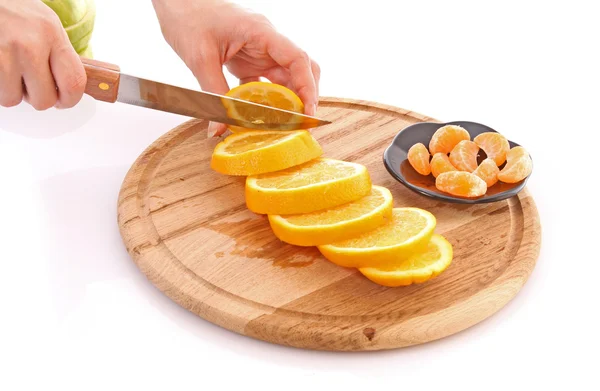 Mani cuting arance sul tavolo — Foto Stock