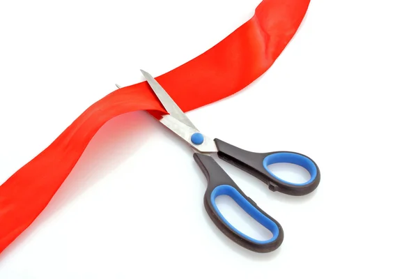 Červená stuha s nůžkami izolovaných na bílém — Stock fotografie
