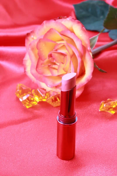 Lipstick and rose on the Textile background — Stock Photo, Image
