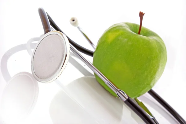 白い背景の聴診器と緑のリンゴ — ストック写真