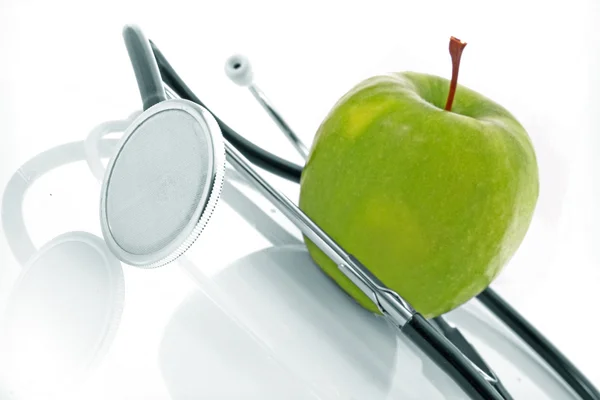 白色背景的听诊器和绿色苹果 — 图库照片