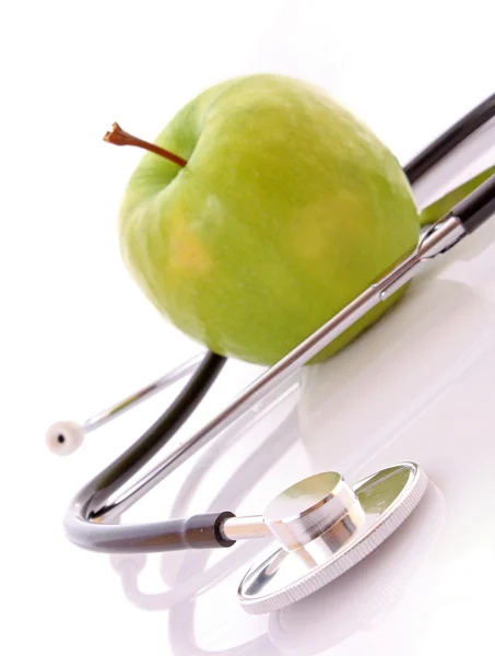 Stethoscoop en groene appel op witte achtergrond — Stockfoto