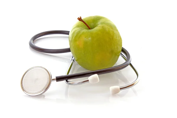 Estetoscopio y manzana verde sobre fondo blanco — Foto de Stock