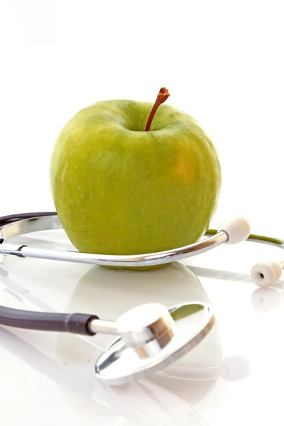 Stetoskop a zelené jablko — Stock fotografie