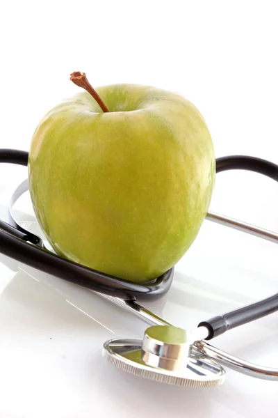 Stéthoscope et pomme verte sur fond blanc — Photo