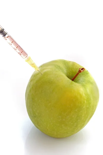 Зеленое яблоко со шприцем на белом фоне — стоковое фото