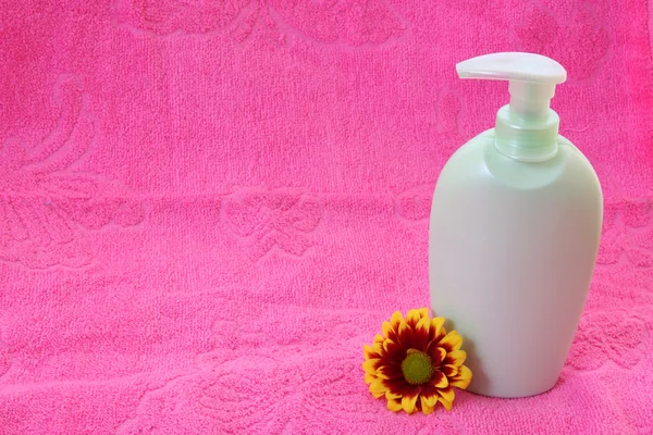 Flüssigseife, Blume und Handtuch auf rosa — Stockfoto