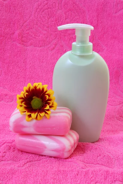 Liquid soap, flower and towel on pink — Stock Photo, Image