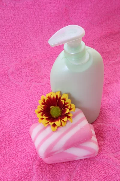Tvål, blomma och handduk på pink — Stockfoto