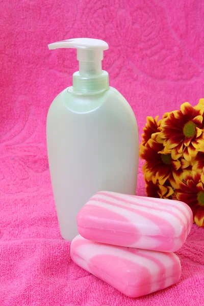 Sabão líquido, flor e toalha em rosa — Fotografia de Stock