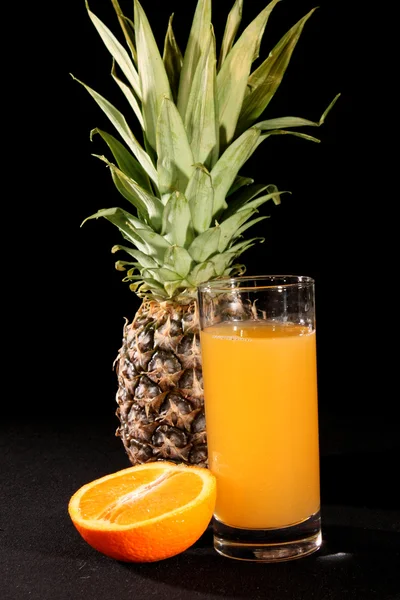 Piña y zumo de naranja sobre fondo negro — Foto de Stock