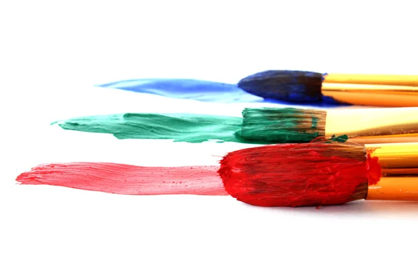 Pincéis de tinta em tinta colorida — Fotografia de Stock