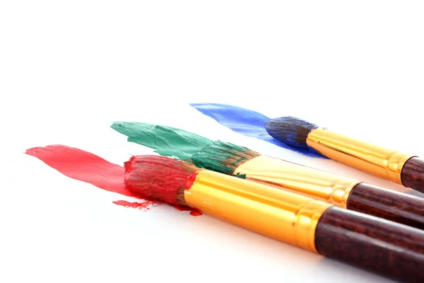Paint brushes in color paint — Stock Photo, Image