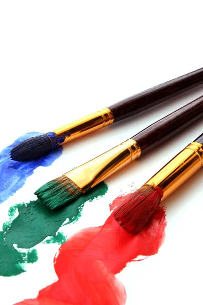 Pincéis de tinta em tinta colorida — Fotografia de Stock