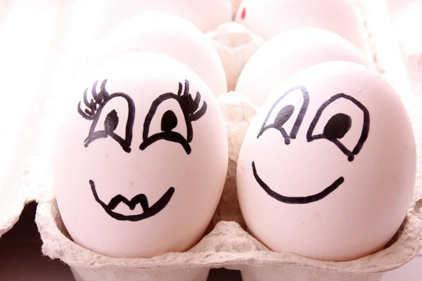 Twee eieren met gezichten op wit — Stockfoto