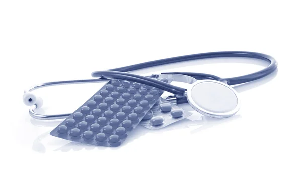 Stetoskop og tabletter på hvit bakgrunn – stockfoto