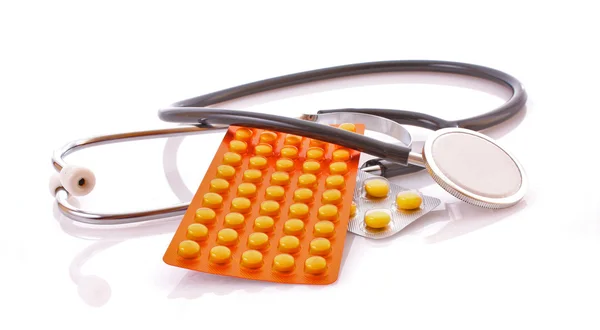 Artsen stethoscoop en tabletten op witte achtergrond — Stockfoto
