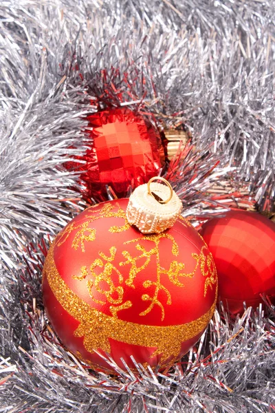 Rote Weihnachtskugeln inmitten silbrig glitzernder Dekoration — Stockfoto