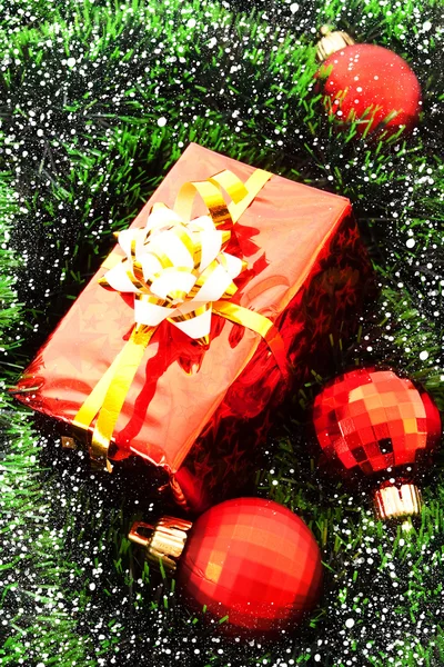 Червоні різдвяні кульки та подарунки серед зеленої новорічної ялинки — стокове фото