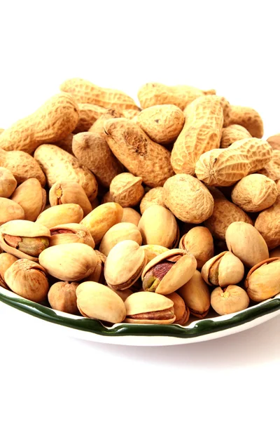 Erdnüsse mit Schalen auf dem Teller isoliert auf weiß — Stockfoto