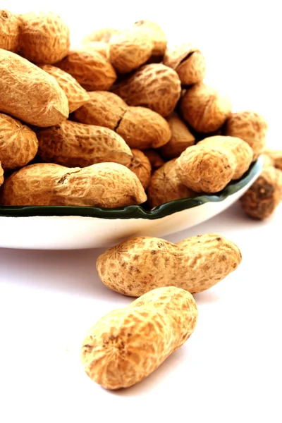 Amendoim com conchas na placa isolado em branco — Fotografia de Stock