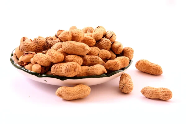 Amendoim com conchas na placa isolado em branco — Fotografia de Stock