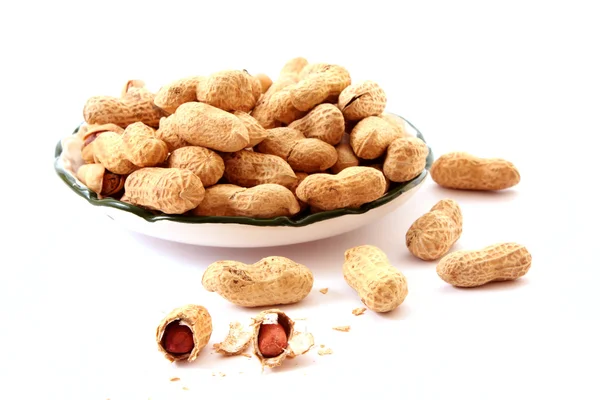 Peanuts with shells on the plate isolated on white — Stock Photo, Image