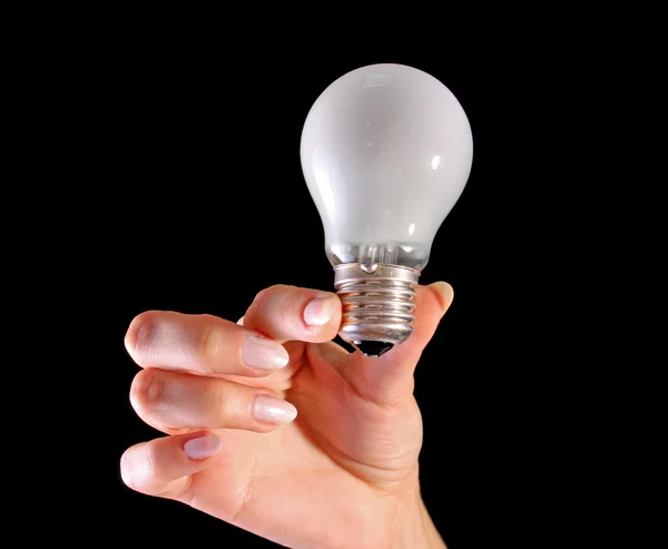 Mão com lâmpada no fundo preto — Fotografia de Stock
