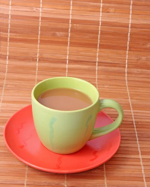 Kawa z mlekiem kolor kubek na tle słomek bambusa — Zdjęcie stockowe