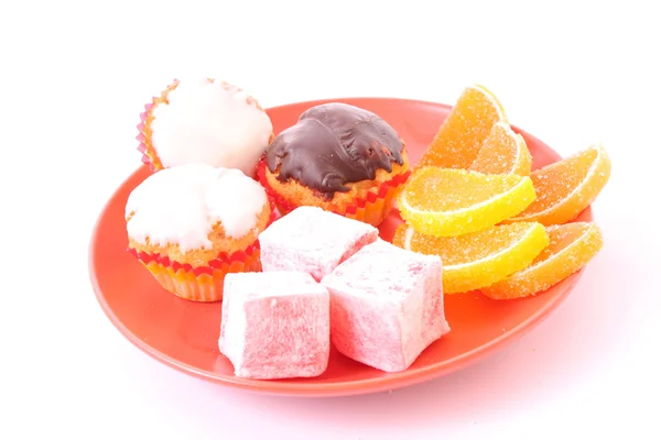 Muchos pasteles y jalea de fruta en el plato aislado en blanco — Foto de Stock