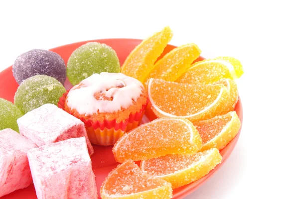 Багато тортів і фруктового желе на тарілці ізольовані на білому — стокове фото