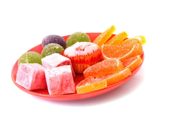 Многие торты и фруктовое желе на тарелке изолированы на белом — стоковое фото