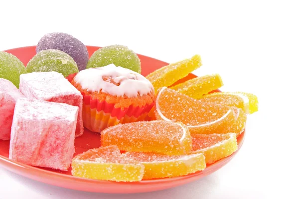 Veel cakes en fruit gelei op plaat geïsoleerd op wit — Stockfoto