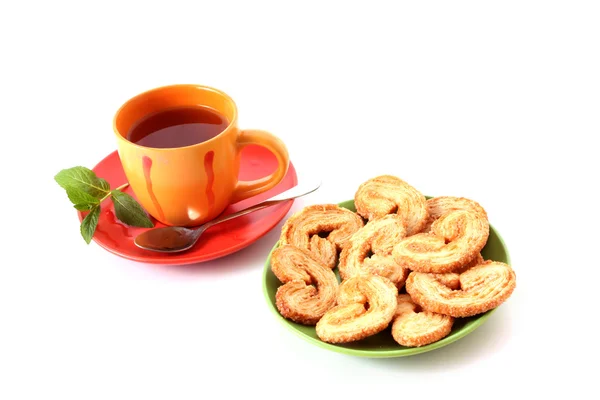 Чашка зеленого чая на блюдце с мятой и печеньем — стоковое фото