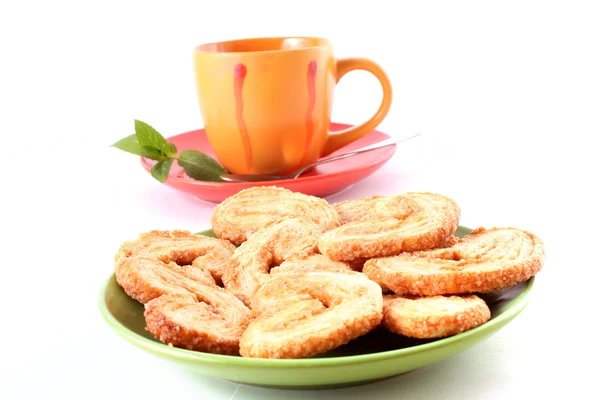 Taza de té verde en el platillo con menta y galletas — Foto de Stock
