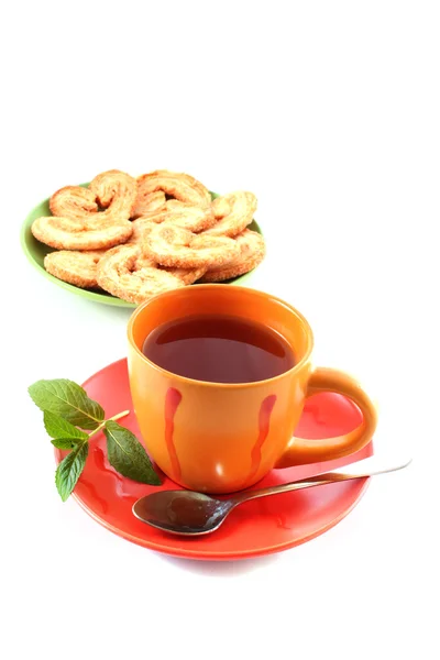 Taza de té verde en el platillo con menta y galletas — Foto de Stock