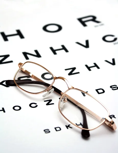 Óculos na carta de teste — Fotografia de Stock